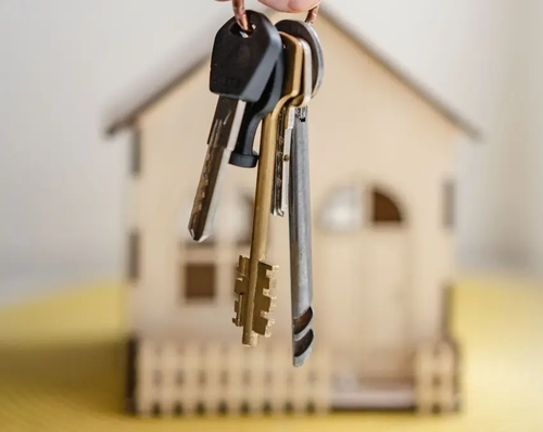 Kto-potrzebuje-swiadectwa-charakterystyki-energetycznej - klucze do domu - z tyłu widoczna makieta domu